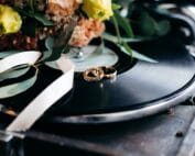 Wedding rings on a record player with flowers